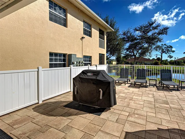 a view of a patio with table and chairs with wooden floor and fence