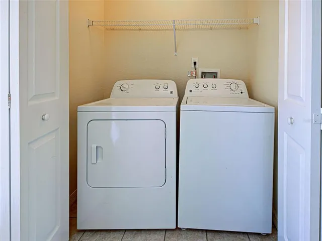 a kitchen with granite countertop a refrigerator sink and white cabinets