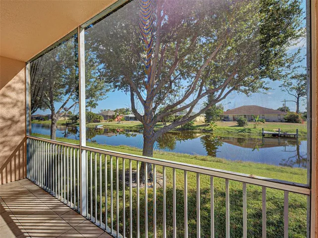 an empty room with wooden floor chandelier fan and windows