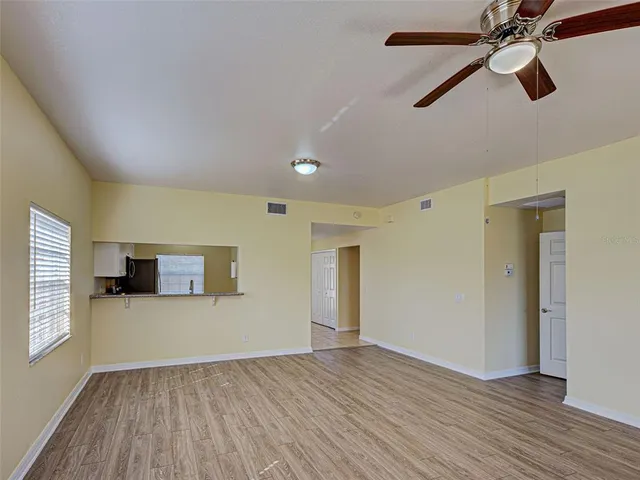 a view of a hallway with wooden floor and a livingroom