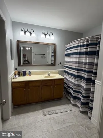 a bathroom with a double vanity sink mirror and bathtub