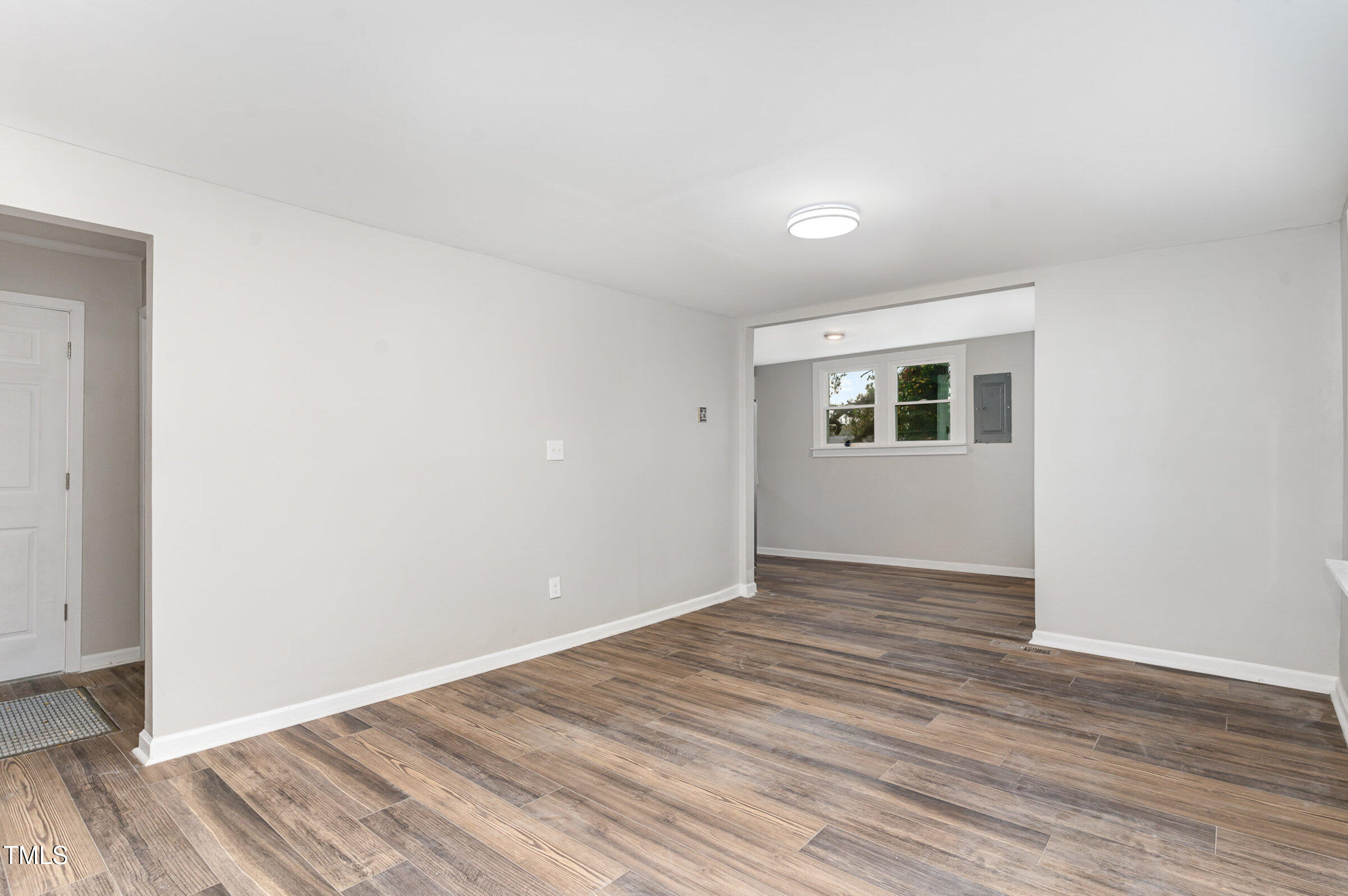 1323 Camden Road Fayetteville, NC 28306 - Photo 6 of 30 a view of an empty room with wooden floor and a window