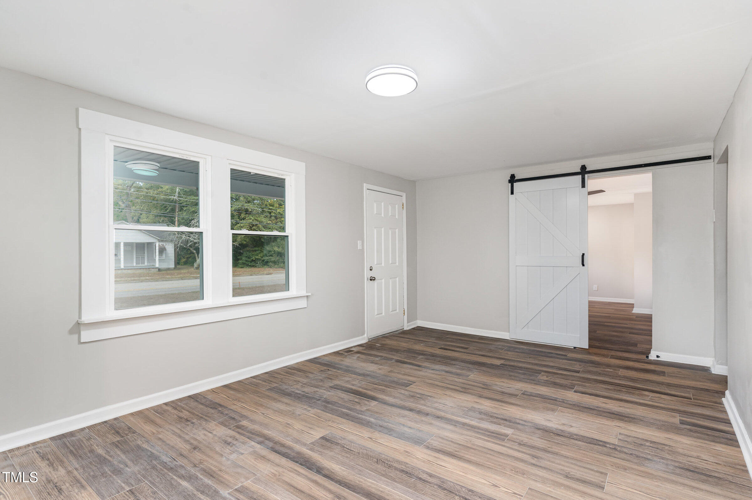 1323 Camden Road Fayetteville, NC 28306 - Photo 7 of 30 a view of an empty room with wooden floor and a window