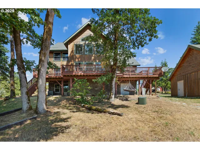 a backyard of a house with large tree and a yard