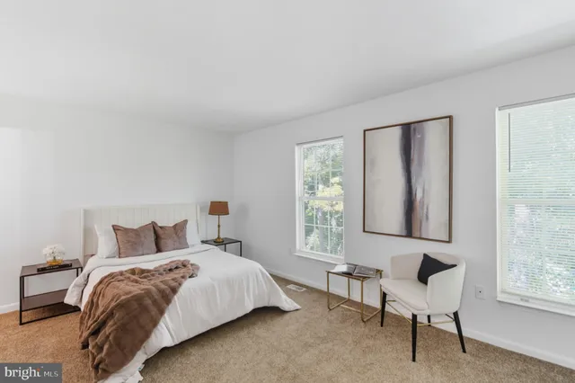 a bedroom with a bed chair and window