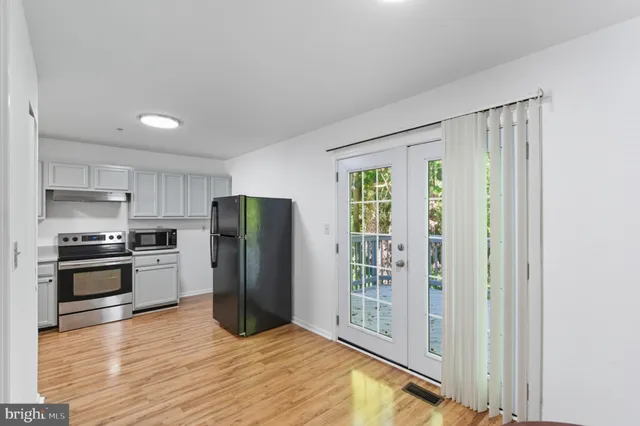 a kitchen with stainless steel appliances granite countertop a refrigerator and a stove top oven