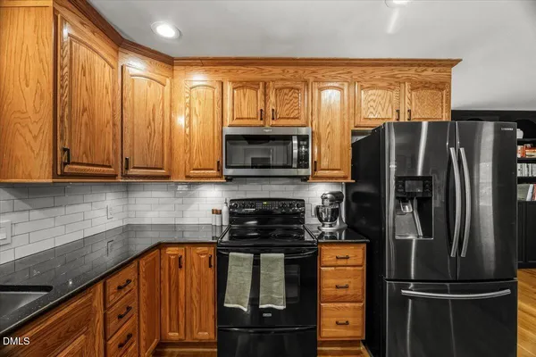 a kitchen with stainless steel appliances granite countertop a refrigerator stove and sink