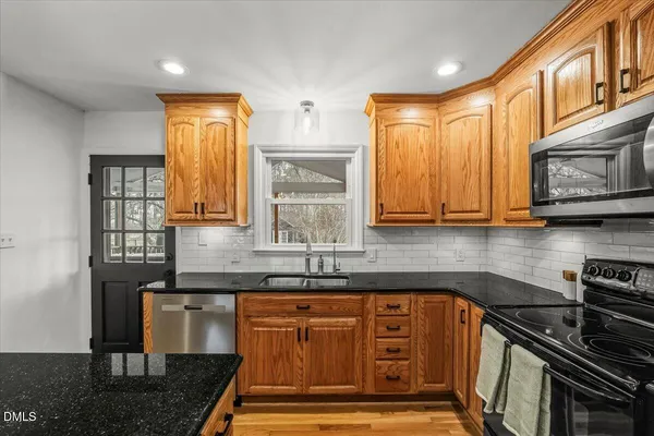 a kitchen with stainless steel appliances granite countertop a sink stove and cabinets