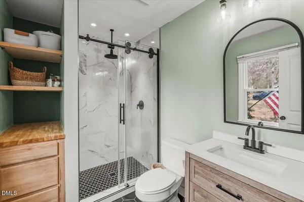 a bathroom with a sink a toilet and shower