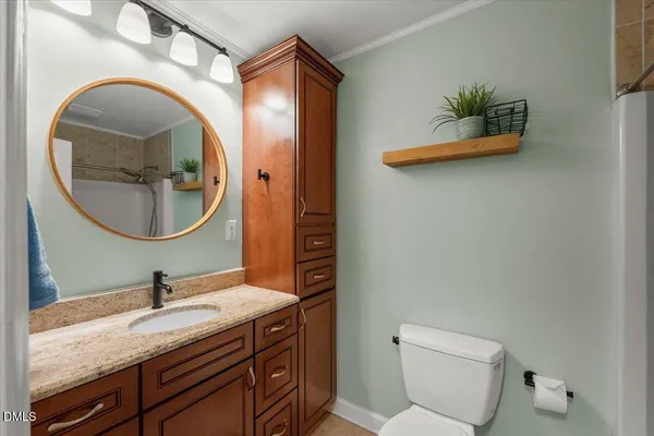 a bathroom with a granite countertop toilet sink and mirror