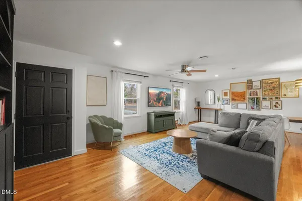 a living room with furniture and a wooden floor