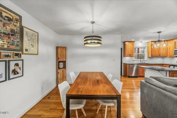 a living room with stainless steel appliances kitchen island granite countertop a kitchen island a stove a oven a sink with island and chairs