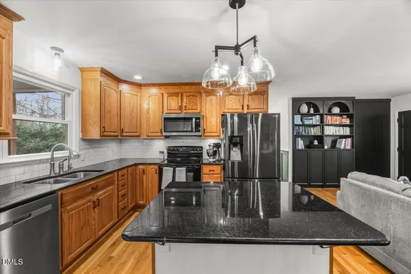 a kitchen with stainless steel appliances granite countertop a sink a stove and refrigerator