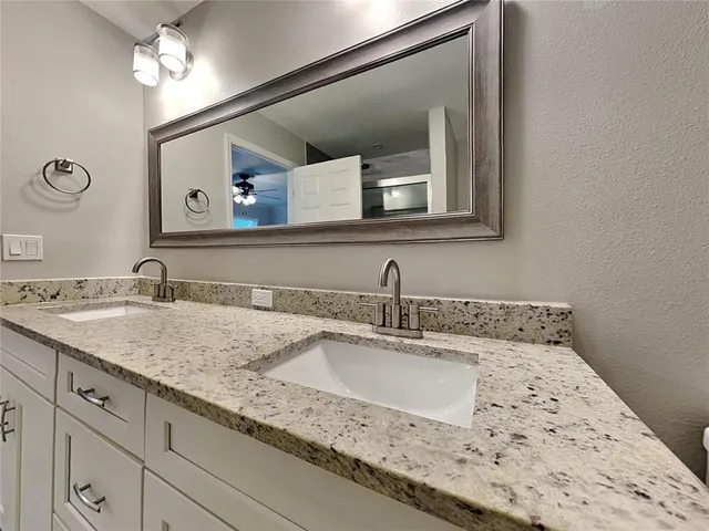 a bathroom with a double vanity sink and a mirror