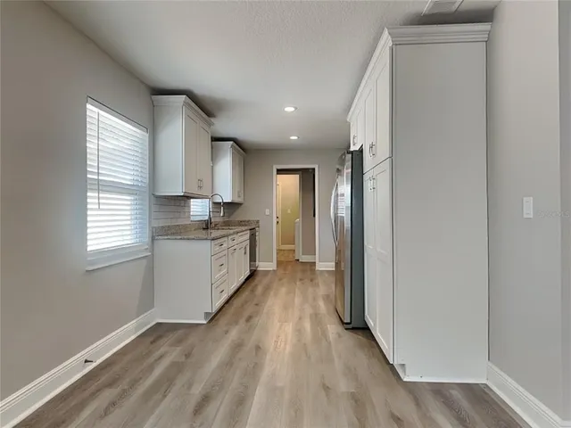 a view of kitchen with wooden floor and electronic appliances