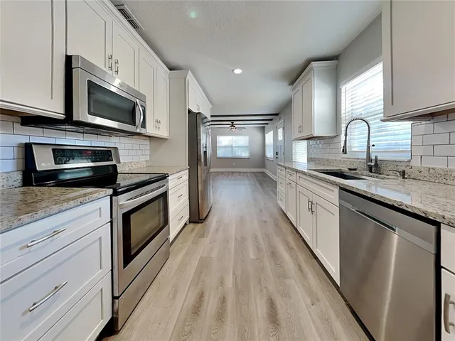 a kitchen with stainless steel appliances a sink dishwasher stove microwave and cabinets