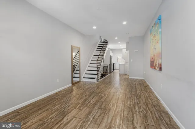 a view of empty room with wooden floor and stairs