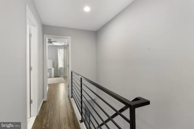 a view of a hallway with wooden floor and staircase