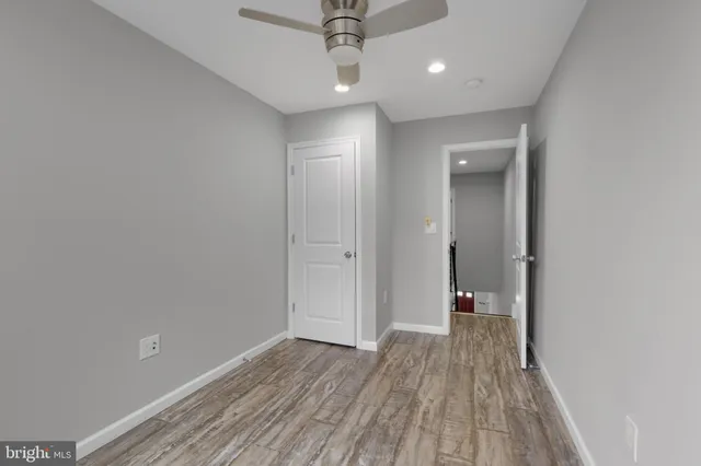 a view of a hallway with wooden floor and a chandelier