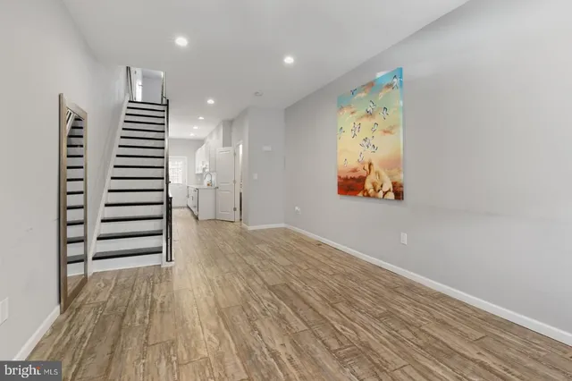 an empty room with wooden floor closet and windows