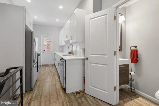 a kitchen with cabinets and wooden floor