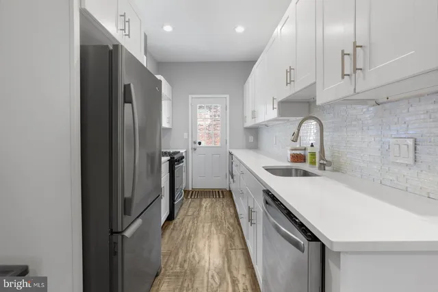 a kitchen with a sink a counter space and stainless steel appliances