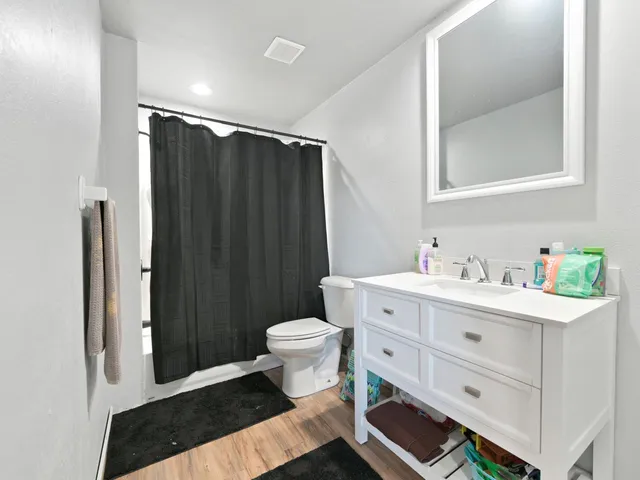 a view of a backyard with wooden fence and a large tree