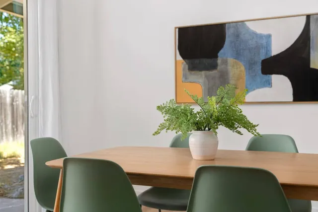 a view of a dining room with furniture and potted plant