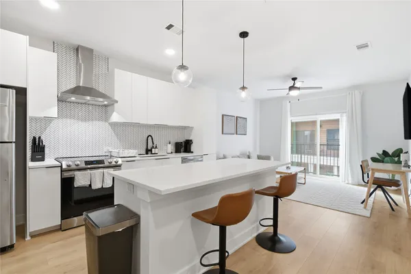 a large kitchen with kitchen island a stove a sink a stove and a refrigerator