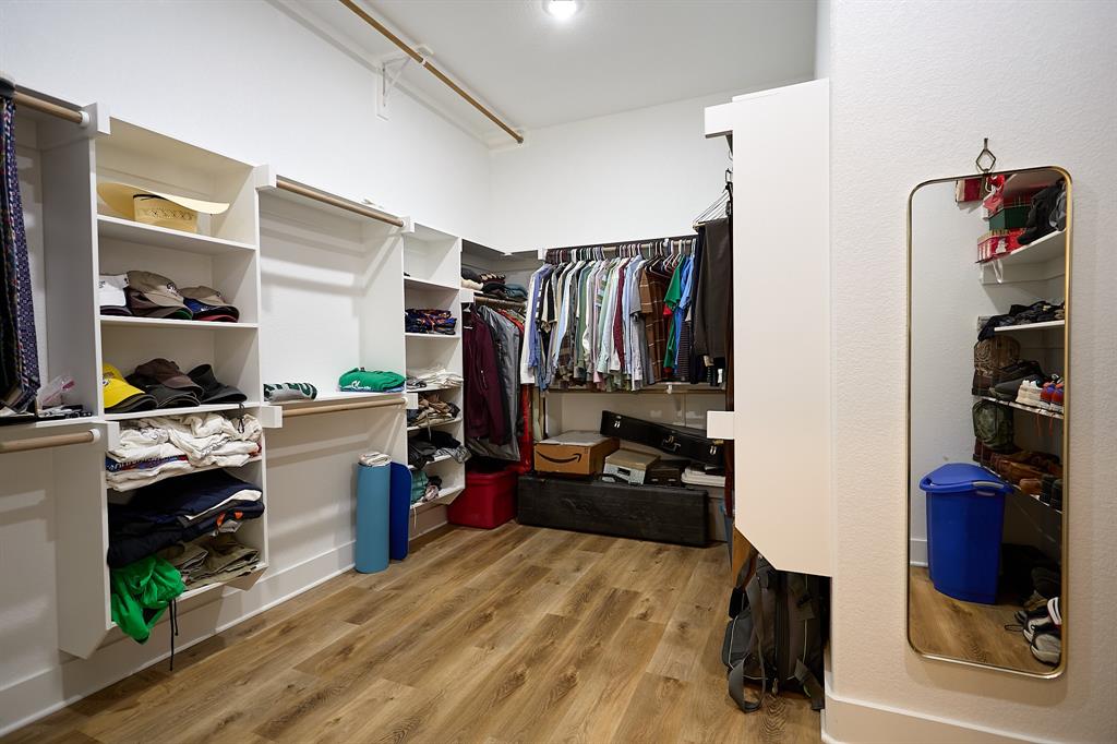 358 Glade Valley Road Azle, TX 76020 - Photo 16 of 35 Walk-in closet featuring wood-finish flooring, white built-in shelving, multiple hanging rods, and recessed lighting
