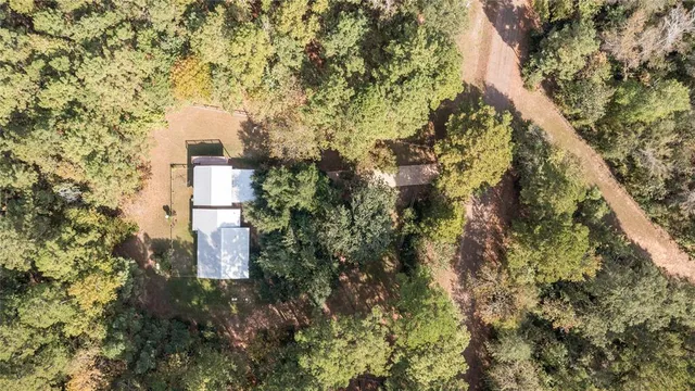 a close up of a house with a yard and large trees