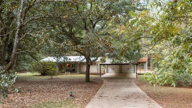 a front view of a house with a yard and trees