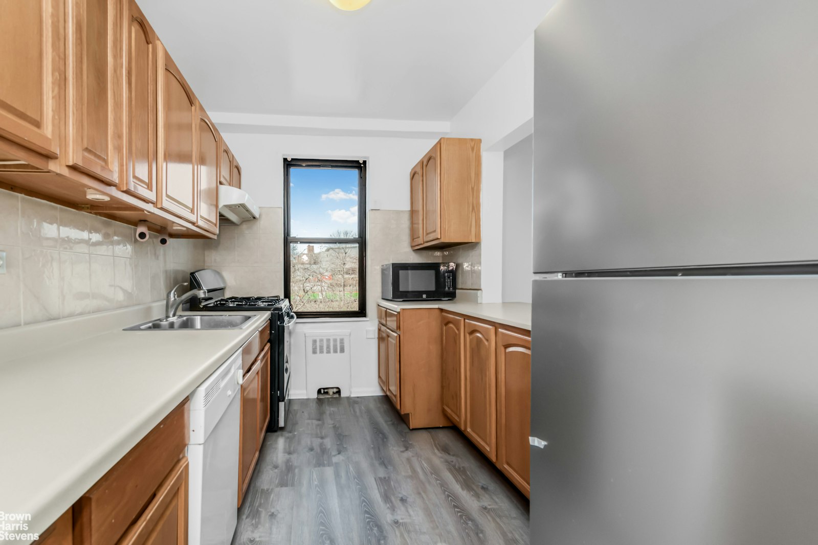 3840 Greystone Avenue, Unit 5L Bronx, NY 10463 - Photo 30 of 41 a kitchen with a sink a stove top oven and white stainless steel appliances