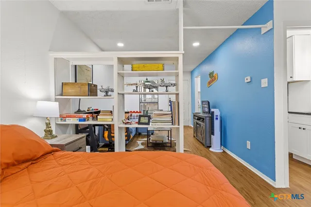 a bedroom with a bed and dresser in it