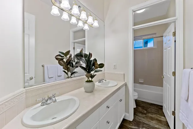 a bathroom with a sink a light fixture and a mirror