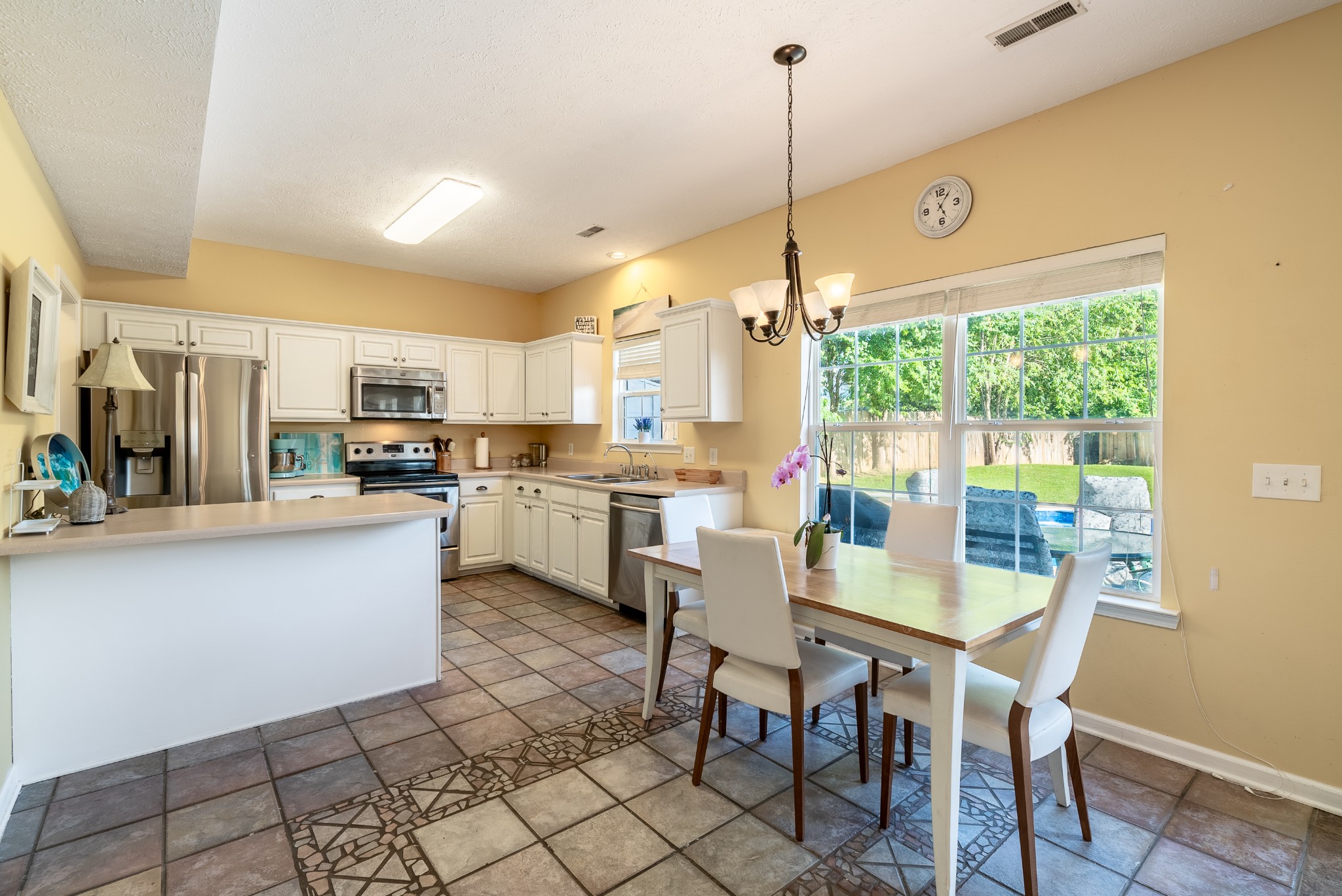 1707 Ginger Way Spring Hill, TN 37174 - Photo 12 of 39 a kitchen with stainless steel appliances granite countertop a stove top oven a sink dishwasher a dining table and chairs with wooden floor