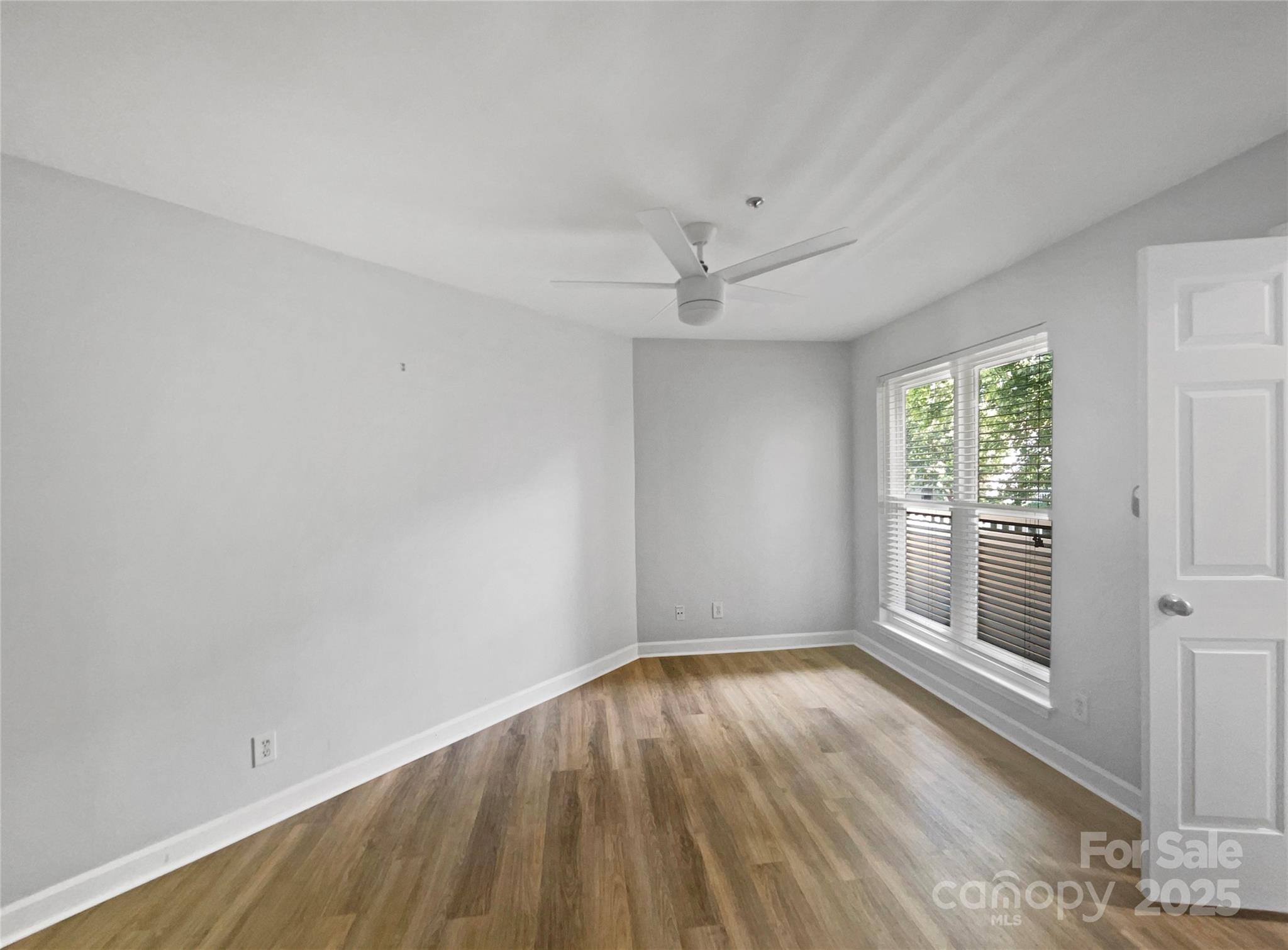 17931 Kings Point Drive, Unit G Cornelius, NC 28031 - Photo 14 of 20 wooden floor in an empty room with a window
