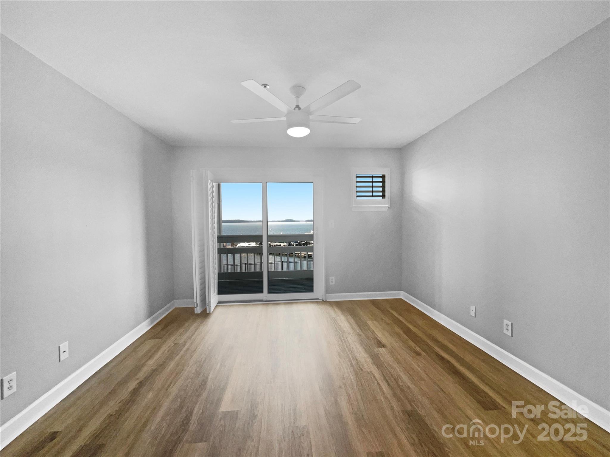 17931 Kings Point Drive, Unit G Cornelius, NC 28031 - Photo 16 of 20 wooden floor in an empty room with a window
