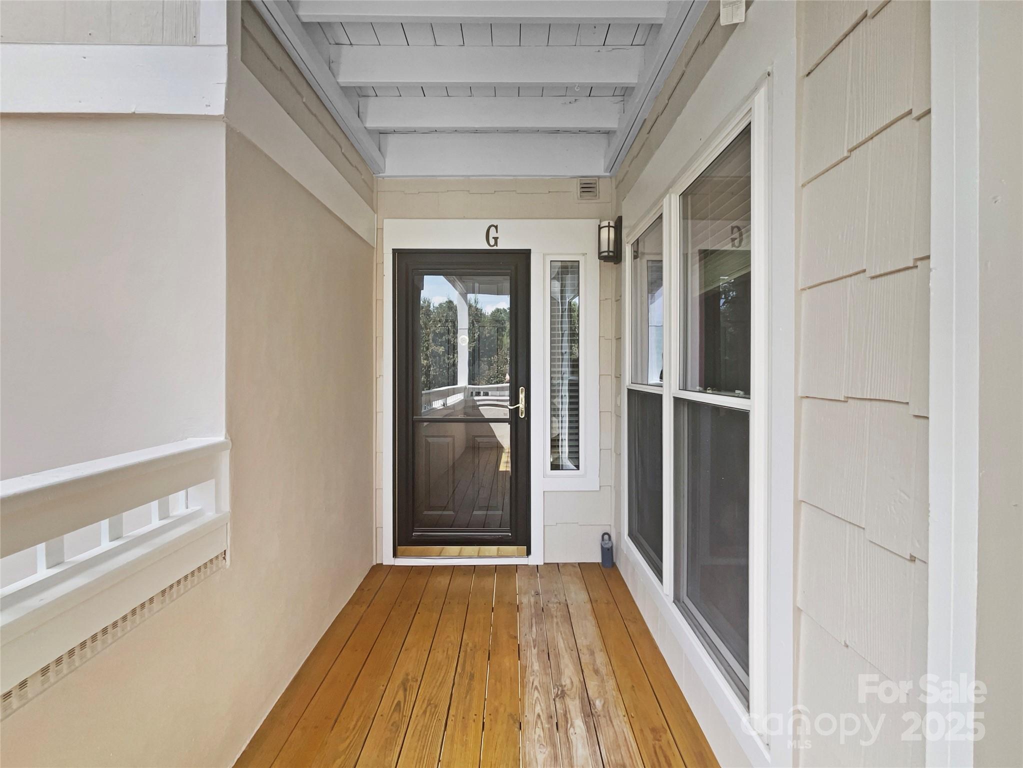 17931 Kings Point Drive, Unit G Cornelius, NC 28031 - Photo 2 of 20 a view of a hallway with wooden floor and a bathroom