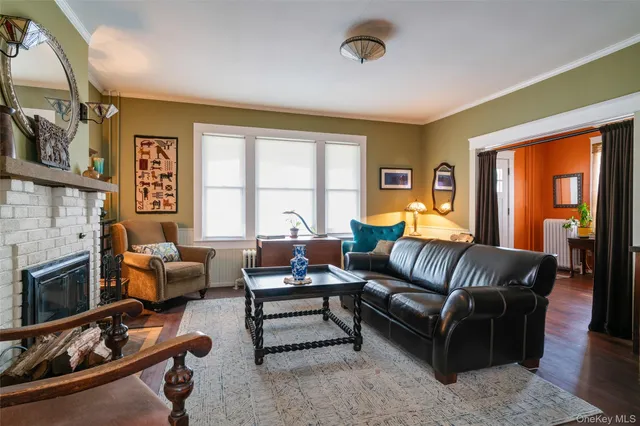 a living room with furniture fireplace and a large window