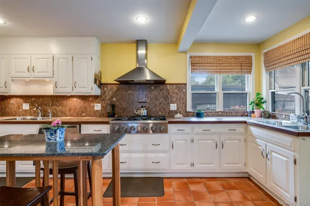 a kitchen with granite countertop a sink a stove and cabinets