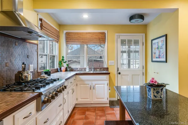 a kitchen with stainless steel appliances granite countertop a stove and a dining table