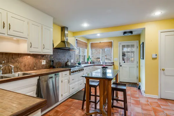 a kitchen with stainless steel appliances granite countertop a sink and a refrigerator