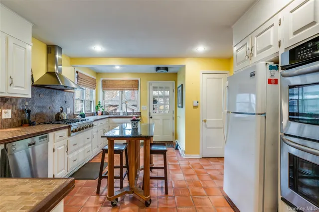 a kitchen with stainless steel appliances granite countertop a refrigerator and a stove top oven