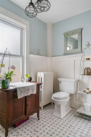 a bathroom with a toilet a sink and a mirror