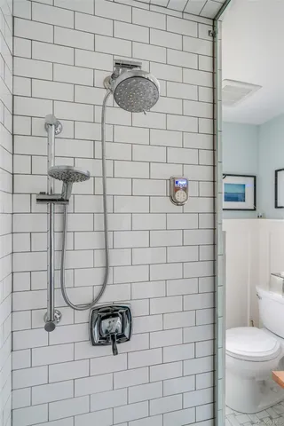 a bathroom with a toilet and a shower