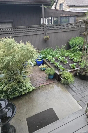 a patio with table and chairs and potted plants