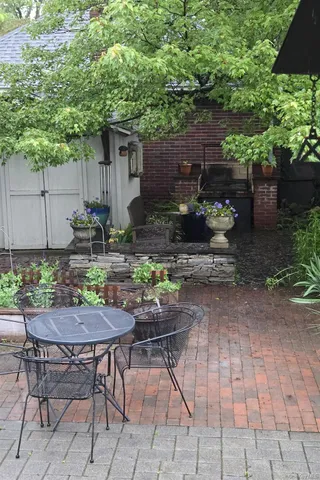 a view of a house with backyard outdoor seating and wooden fence