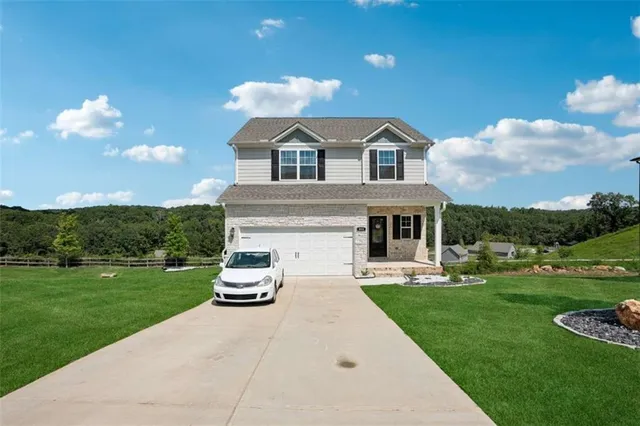 a front view of a house with a garden and pathway