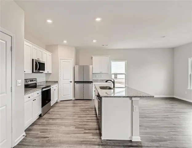a kitchen with stainless steel appliances a refrigerator sink and microwave